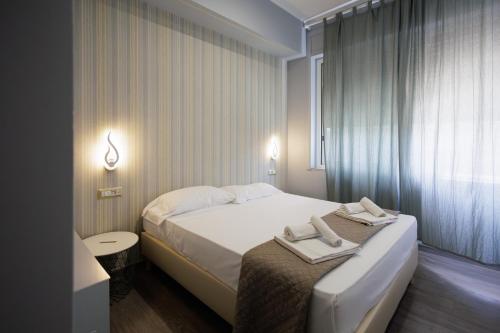 a bedroom with a bed with two towels on it at La Palazzata Urban Suites in Messina