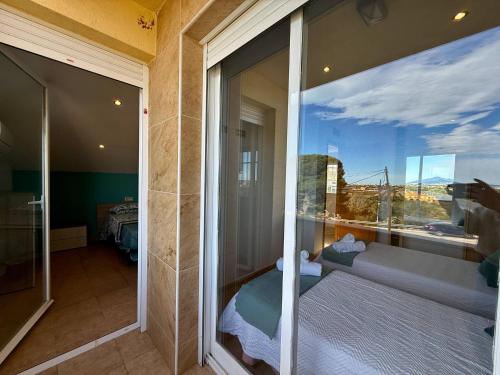 a room with a balcony with a view of a bedroom at Los Olivos - Casa Adosada in Peniscola