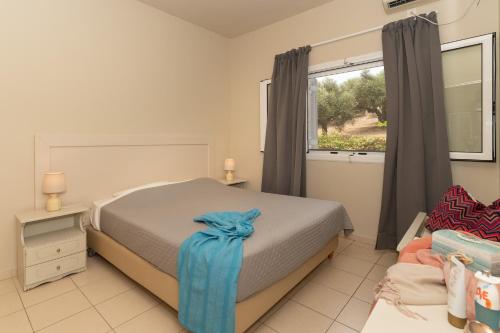 a bedroom with a bed with a blue bow on it at Dion Zois in Finikounta