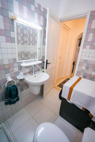 a bathroom with a sink and a toilet and a bed at Villa Bianca 2 in Fafou
