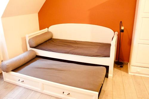 a bunk bed in a room with an orange wall at Escapade au Mont St Michel in Pleine-Fougères