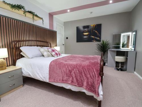 a bedroom with a large bed with a wooden headboard at Steam and Stay Hoole in Chester