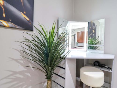 a bathroom with a white desk with a potted plant at Steam and Stay Hoole in Chester