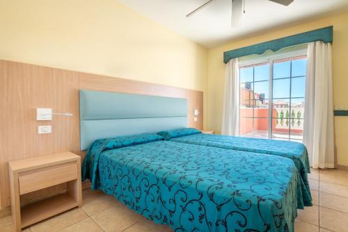 a bedroom with a bed and a large window at OBSIDIAN Granada Park in Arona