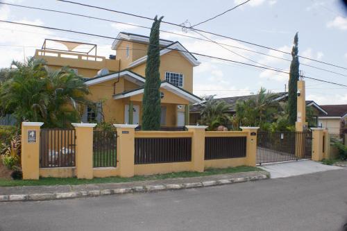 a yellow fence in front of a house at The Vista Inn Studio #1 in Falmouth