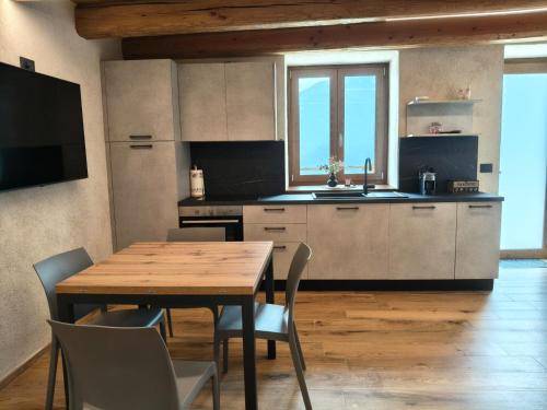 a kitchen with a wooden table and a table and chairs at Alloggio Bellavista in Rore