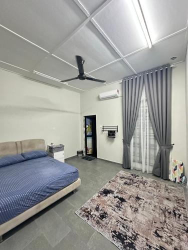 a bedroom with a bed and a ceiling fan at Homestay Anaza in Kampong Balai Maras
