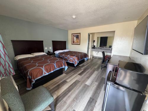 a hotel room with two beds and a flat screen tv at Village Inn in Ada