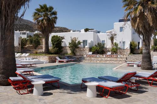 a pool with chaise lounge chairs and palm trees at Soleil Hotel Paros in Drios