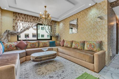 a living room with a couch and a chandelier at Gated oceanfront residence - chic apartment in Salé