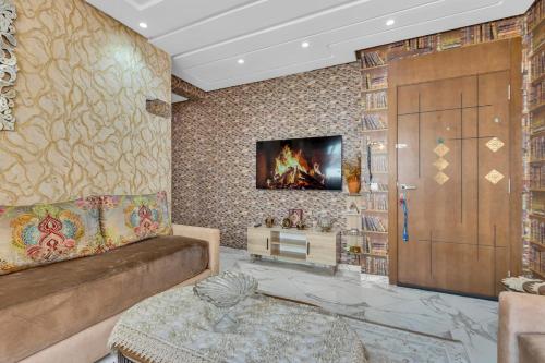 a living room with a couch and a tv on a wall at Gated oceanfront residence - chic apartment in Salé