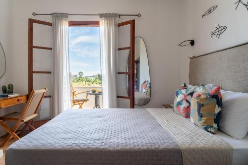 a bedroom with a bed and a desk and a window at Jimmy's Guest House Skiathos in Skiathos