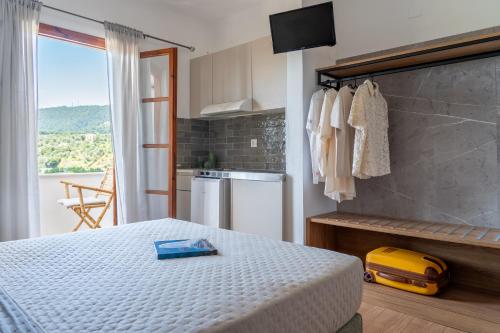 a bedroom with a bed and a view of a kitchen at Jimmy's Guest House Skiathos in Skiathos