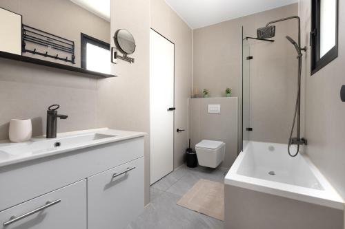 a white bathroom with a sink and a toilet at דקוטה 11 Dakota in Eilat