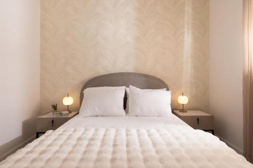 a bed with two white pillows and two lamps at דקוטה 11 Dakota in Eilat