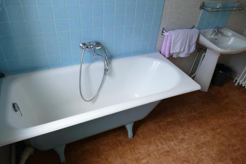 a bath tub and a sink in a bathroom at Hôtel Modern in Concarneau