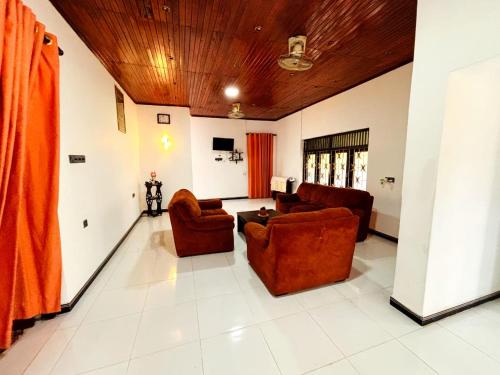 a living room with two chairs and a couch at Orchid Resort in Medawachchiya