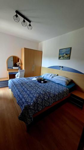 a bedroom with a bed with a blue comforter at Apartman Rab Blue in Rab