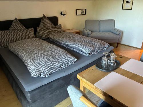a living room with a couch and a chair at Haus Chiemseeblick in Grabenstätt