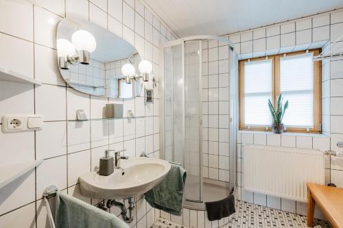 a white bathroom with a sink and a mirror at Ferienwohnungen Lusenblick in Freyung