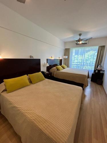 ein Hotelzimmer mit zwei Betten und einem Fenster in der Unterkunft Palermo Bridge in Buenos Aires