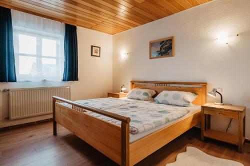 a bedroom with a bed and a window at Ferienwohnungen Lusenblick in Freyung