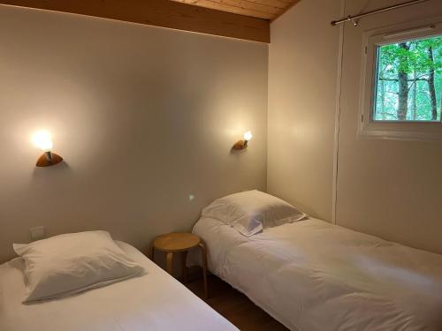 two beds in a room with two lights on the wall at SAS Le Bataillet in Montégut
