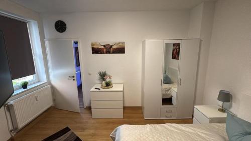 ein Schlafzimmer mit einem Bett, einer Kommode und einem Spiegel in der Unterkunft Stadtoase 3 in Wittenberge