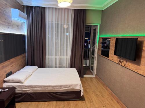 a bedroom with a bed and a flat screen tv at Temiz Hotel in Alanya