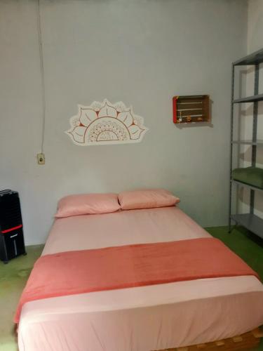 a bedroom with a bed with pink and orange sheets at Casa da Pri em São Jorge in Sao Jorge
