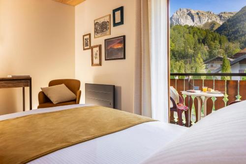 ein Schlafzimmer mit Bett und Balkon mit Aussicht in der Unterkunft Les Cornettes in La Chapelle-dʼAbondance