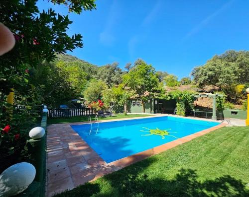 a swimming pool in the yard of a house at Finca rural Labriega del hueznar in Cazalla de la Sierra