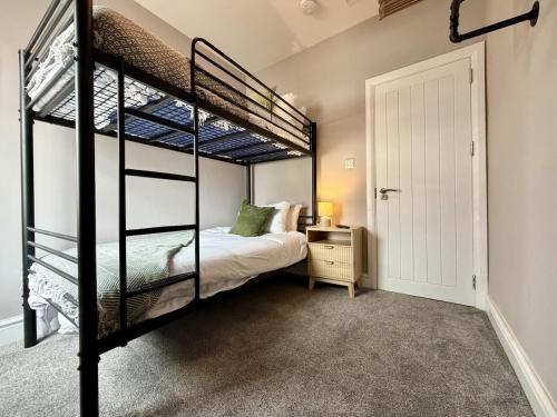 a bedroom with two bunk beds and a door at Hazel, Spacious 3-Bed Home in Dowlais