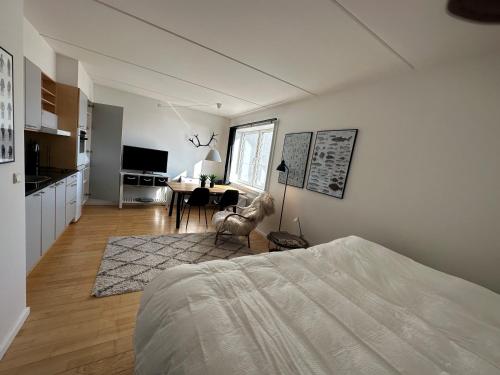 a bedroom with a bed and a kitchen with a table at Aurora Studio Apartments in Nuuk