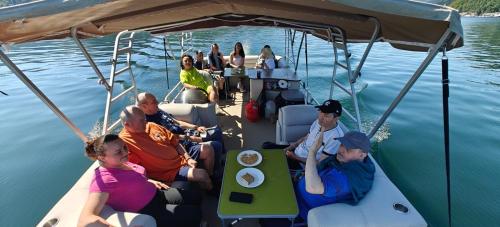 a group of people sitting on a boat in the water at La Coca Lake House in Bicaz