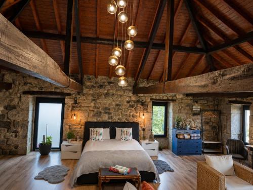 a bedroom with a bed and a stone wall at Open Space com Jacuzzi a 5 mn do centro de Lamego in Lamego