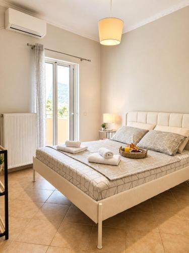 a bedroom with a large bed with a large window at VALERIA Apartment in Vonitsa
