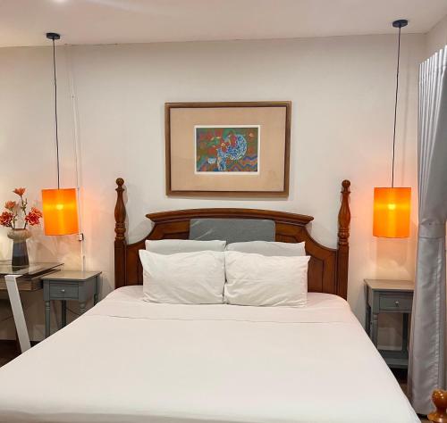 a bedroom with a white bed with two lamps at Tranquility Stay Old Quarter in Hanoi