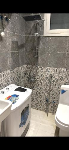 a bathroom with a shower and a toilet and a sink at شالية الفهد in As Sayl al Kabīr