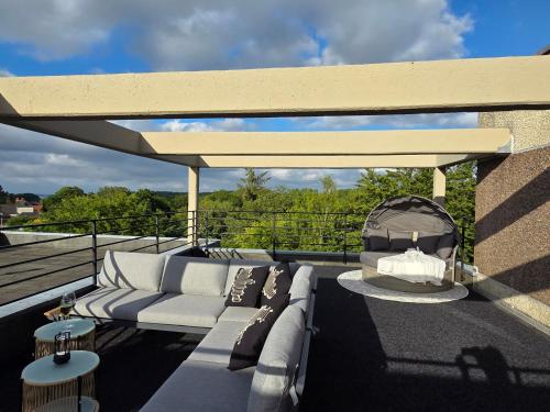 a patio with a couch and a gazebo at Förde Loge - Traumblick & Spa in Glücksburg