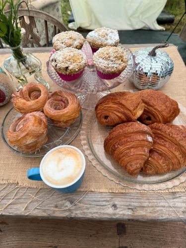 a table topped with plates of pastries and a cup of coffee at Apuldram Roses in Appledram
