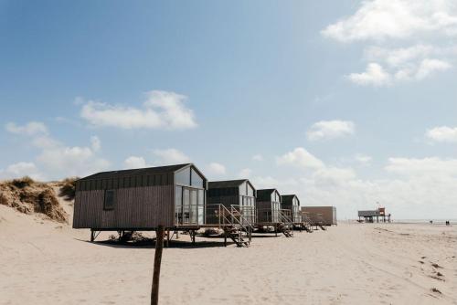 a row of houses on a sandy beach at Puur Petten in Petten