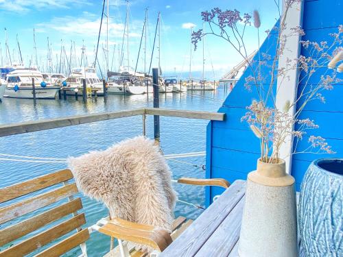 a bench on a boat with boats in the water at Hausboot Yara am Steg 1D in Heiligenhafen