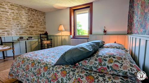 a bedroom with a bed with a comforter and a window at Le Brocangîte à Jules - 4 pers in Bèze