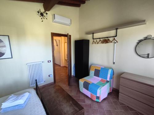 a bedroom with a bed and a chair in a room at Il poggio più 'n giù in Volterra