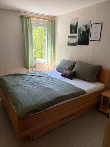 a large bed in a bedroom with a window at Ferienhaus Hirschglück in Alpirsbach