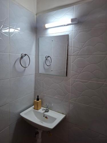 a bathroom with a sink and a mirror at Serene 63 Luxe in Murangʼa