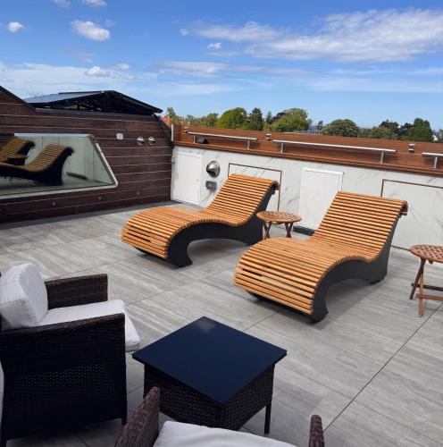 a patio with two chairs and a table on a roof at Mała Anglia Deluxe Rooms & SPA in Sopot