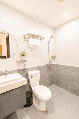 a bathroom with a toilet and a sink at Fame Apartment in Dong Hoi