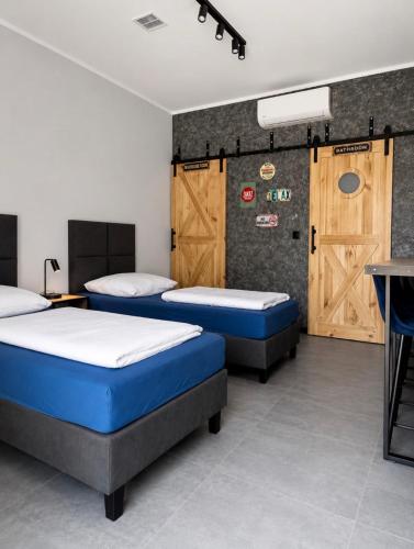 two beds in a room with wooden doors at Noclegi Na Końcu Świata Bielpon in Przemyśl